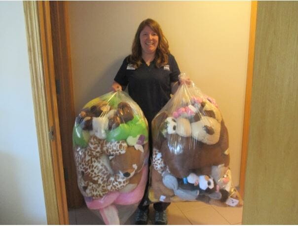 Woman holding bags filled with stuffed animals